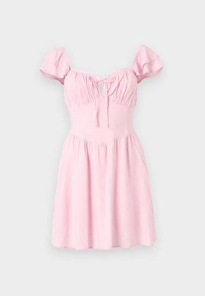 Rožinė suknelė su trumpomis, volanėlėmis, raukšlėta liemine dalimi ir skylių detale. Išsiplėtusi sijonas ir lygi medžiagos tekstūra.