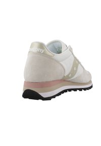 Sneaker di colore chiaro realizzato con una combinazione di suede e materiali sintetici. Presenta un accento dorato nel tallone e una suola stratificata in beige e bianco.
