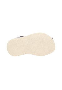Zool van een schoen, voorzien van een textuur van crèmekleurig rubber met horizontale en verticale groeven, die tractie en stabiliteit bieden.