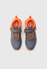 Sötétszürke, narancssárga részletekkel díszített sportcipők, hálós felsőrésszel, tépőzáras pánttal és fűzőkkel; gumitalp és párnázott szegély a kényelemért.