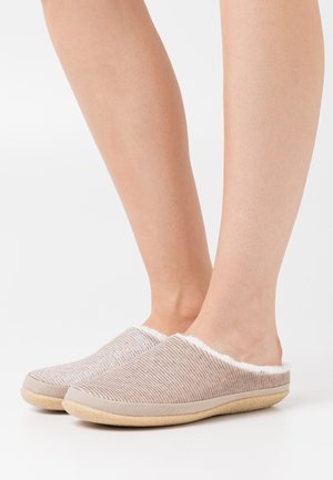 Pantofole leggere senza lacci con un superiore beige testurizzato, morbida fodera bianca e suola in gomma tan. Presentano un design minimalista.