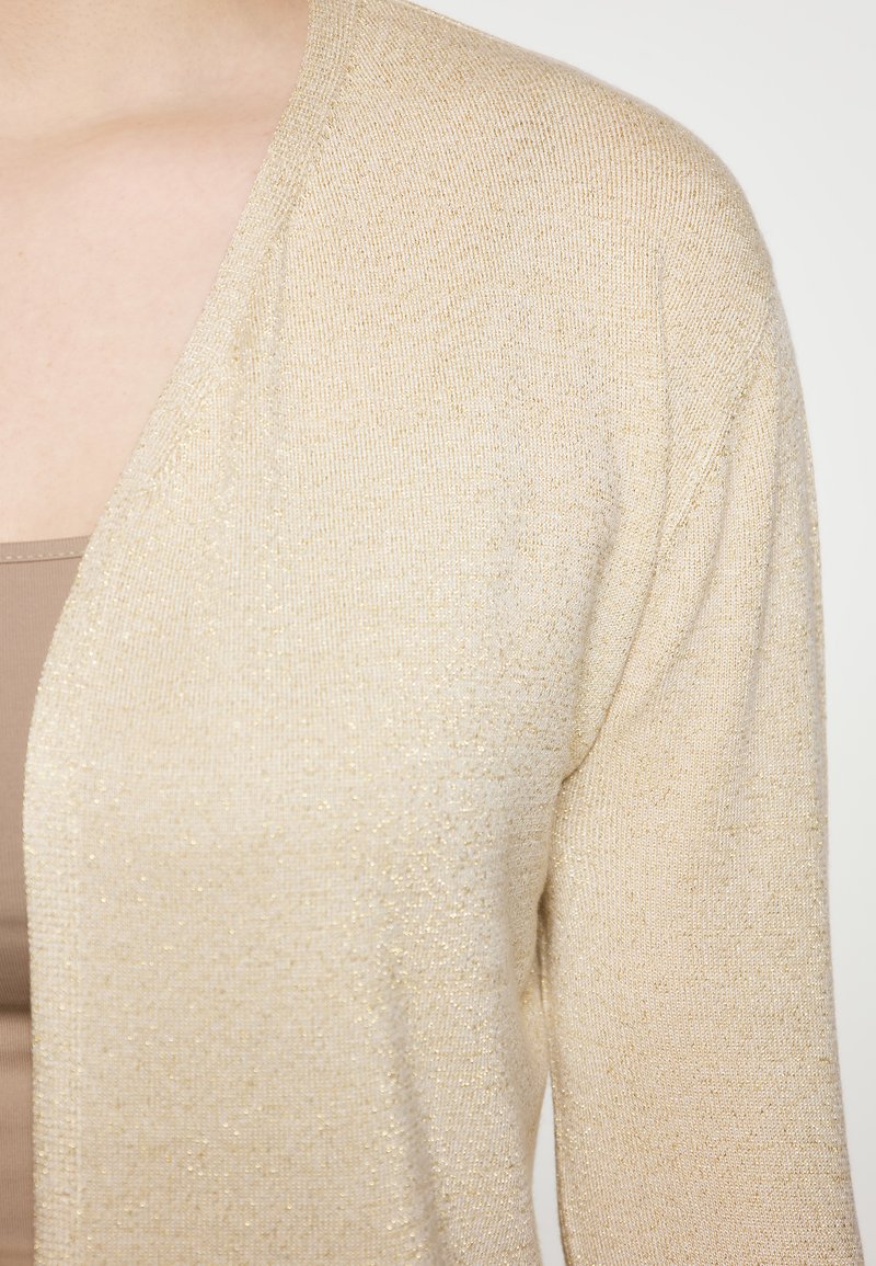 Cardigan beige leggero con una leggera lucentezza, design aperto davanti, tessuto a maglia testurizzato e cuciture delle spalle scese.