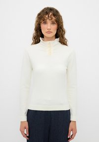 Bílý dlouhý rukáv top s vysokým límcem, čtyřmi ozdobnými knoflíky a žebrovaným lemem, vyrobený z hladkého, měkkého materiálu.