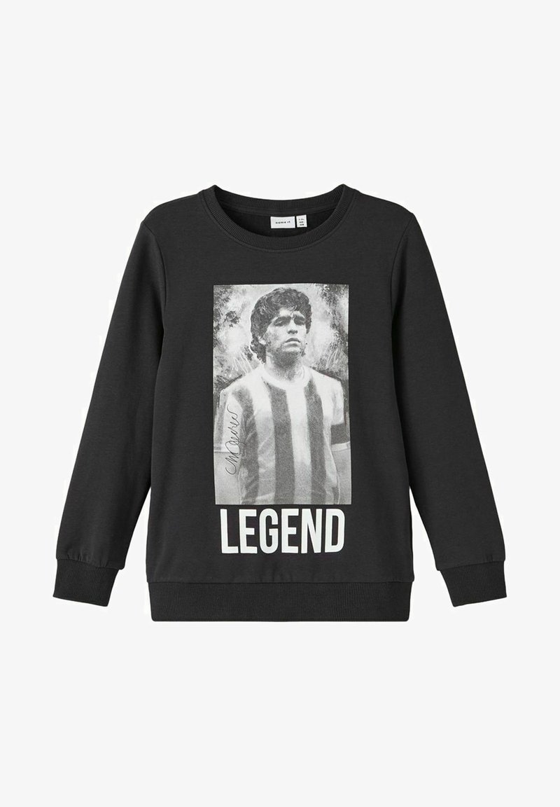 Sweatshirt noir avec un portrait en noir et blanc d'un homme portant un maillot de sport rayé, signature à gauche, et le mot "LÉGENDE" en dessous.