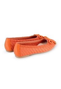 Zapatos planos de mimbre naranjas con punta afilada, cuentan con un tacón de cuero liso naranja y un detalle de lazo decorativo en la parte delantera.