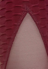 Burgunderfarbene Strumpfhosen mit einem strukturierten Muster und transparenten Mesh-Einsätzen. Verfügt über einen nahtlosen Rand für einen eleganten Look.