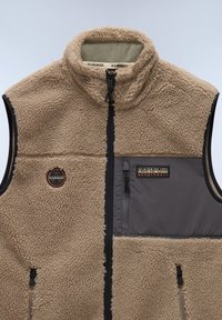 Beige fleece vest with a high collar, gray nylon accents, and zippered pockets. Features branding patch with orange details. Soft texture.