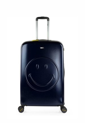Maleta rígida en azul marino con un diseño de cara sonriente en relieve. Cuenta con un mango telescópico y cuatro ruedas giratorias para una fácil maniobrabilidad.