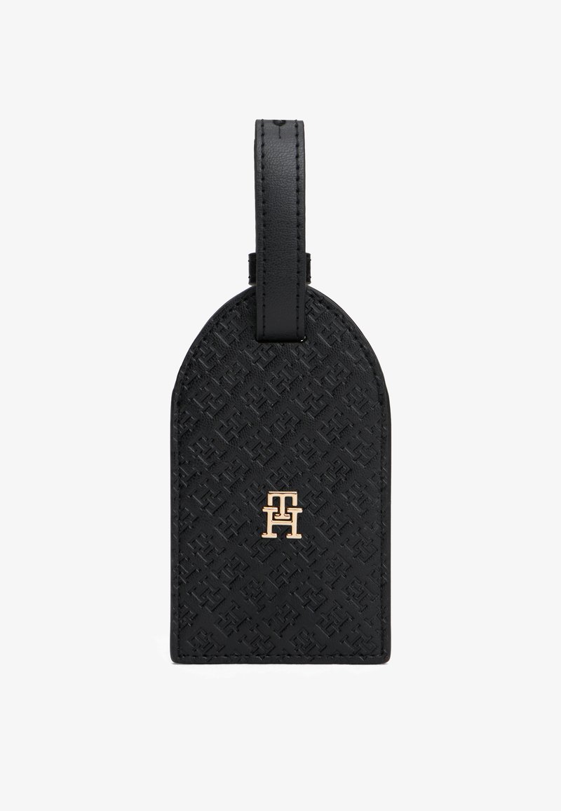 Μαύρη δερμάτινη ετικέτα αποσκευών με ανάγλυφο σχέδιο, στρογγυλεμένη κορυφή και χρυσό λογότυπο στο κέντρο. Διαθέτει ανθεκτικό βρόχο πρόσδεσης.