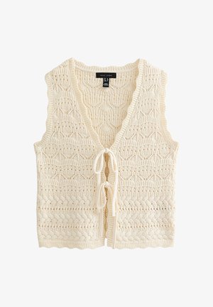 Veste sans manches en tricot couleur crème avec col en V et deux fermetures à nouer à l'avant, présentant un motif texturé en dentelle et tricot torsadé.