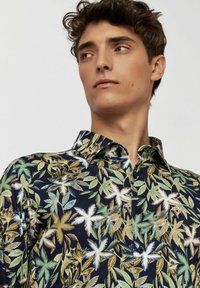Korte mouwen overhemd van marineblauwe stof met een multicolore bladvorm. Met knoopsluiting bij de kraag en een zachte textuur met een relaxed fit.