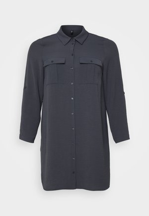 Abito camicia lungo a maniche lunghe di colore grigio scuro con chiusura a bottoni, due tasche sul petto e un tessuto texture. Presenta un colletto classico e maniche arrotolabili.