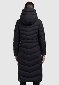 Palton puf negru, lung, cu un model în formă de zig-zag, cu o glugă mare și mâneci lungi. Prezintă o textură matlasată și o siluetă elegantă.