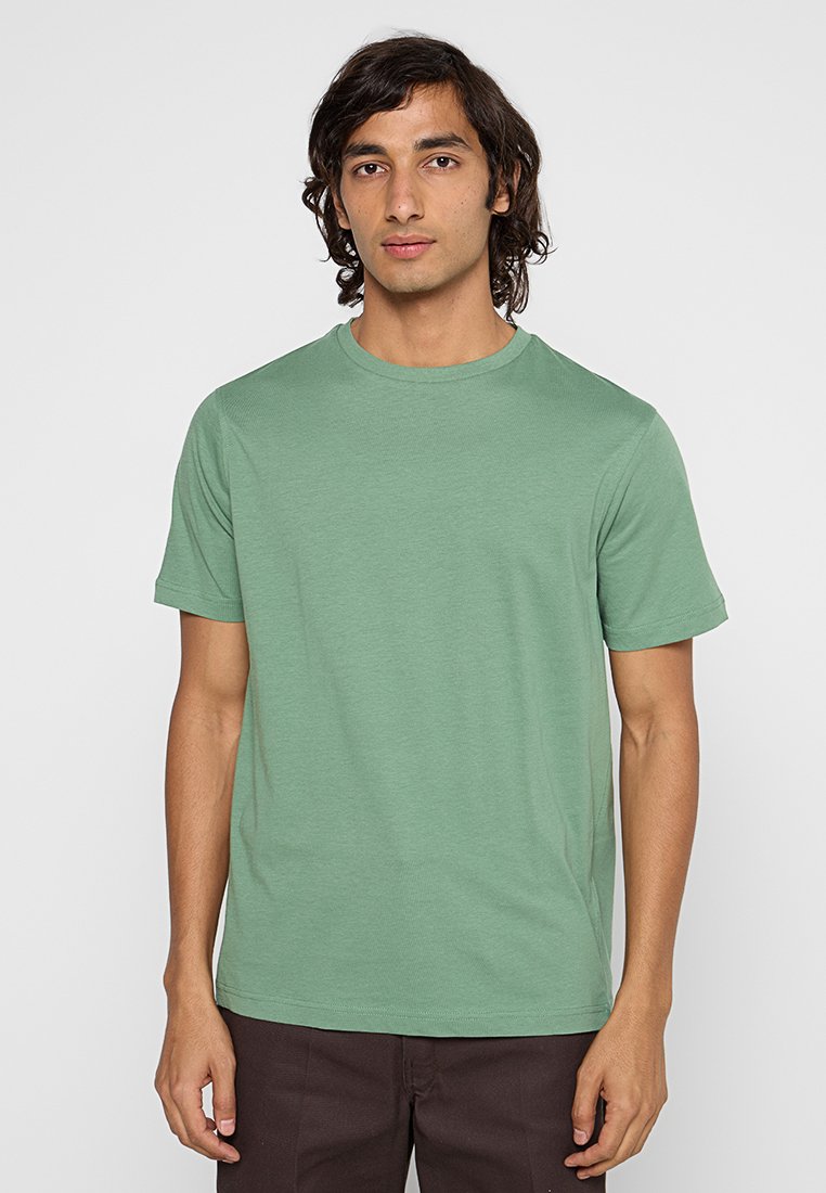 Grünes Baumwoll-T-Shirt mit kurzen Ärmeln und rundem Halsausschnitt. Der Stoff ist glatt und hat einen leichten Stretch. Keine sichtbaren Muster oder Logos.