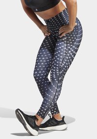 Hoge taille legging in marineblauw met een geometrisch wit patroon. Gemaakt van rekbaar materiaal, met zijnaad en een gladde afwerking.