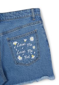 Shorts in denim blu con una tasca posteriore decorata da ricami floreali bianchi e il testo "Mi Ama" e "Non Mi Ama". Dettaglio con orlo sfrangiato.