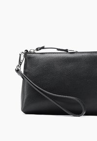 Pochette en cuir noir avec finition texturée, forme fine, fermeture éclair sur le dessus et bracelet détachable. Accessoires en métal argenté.