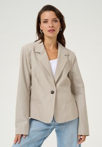 Světlý béžový blazer s jemným proužkem vyrobený z hladké tkaniny, s jedním knoflíkem na zapínání, klopovými límci a kapsami s klopou.