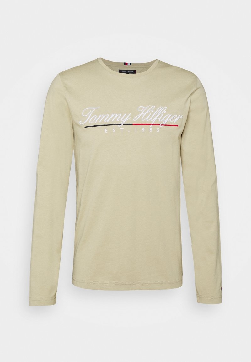 Beige Langarmshirt aus Baumwollmischung, mit "Tommy Hilfiger" Logo in Weiß mit roten und schwarzen Akzenten, Rundhalsausschnitt und normaler Passform.