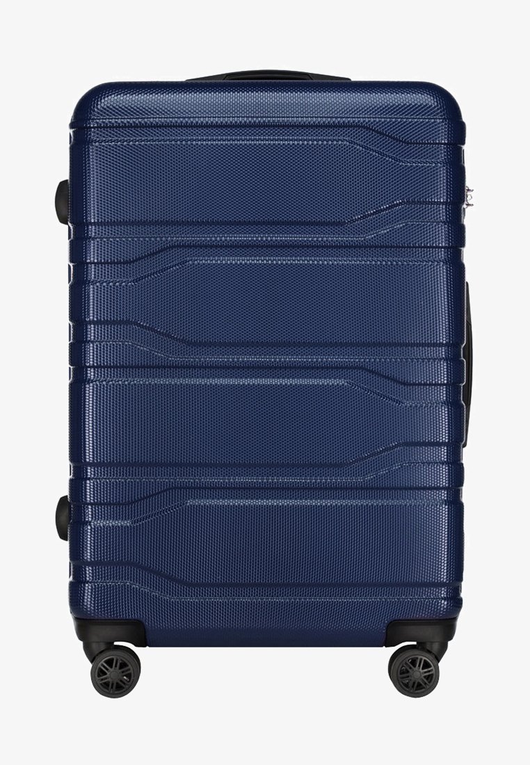 Marineblauwe harde koffer met een gestructureerd oppervlak, meerdere horizontale groeven, vier zwarte wielen en een uitschuifbare handgreep voor gemakkelijke transport.