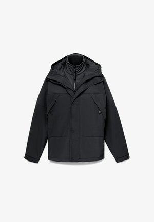 Schwarze Outdoor-Jacke mit einem Reißverschluss am hohen Kragen, verstellbare Kapuze und mehreren Fronttaschen in einem strukturierten Design und glatter Textur.