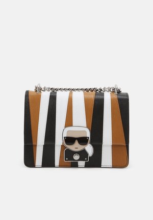 Bunte gestreifte Handtasche mit braunen, schwarzen, weißen und orangen Abschnitten, einem metallichen Charakterakzent auf der Vorderseite und einem Kettenriemen.