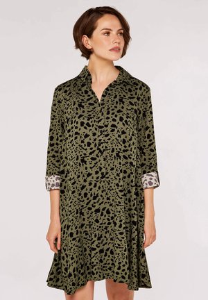 Grünes Hemdkleid mit schwarzem gepunktetem Muster, Dreiviertelärmeln und kontrastierenden Leopardenmuster-Bündchen. Fließende Silhouette.
