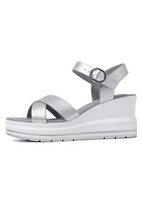 Sandali wedge argento con cinturini incrociati e cinturino alla caviglia regolabile. Texture liscia, soletta imbottita e una spessa suola piattaforma bianca.