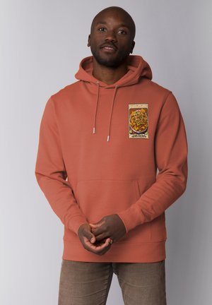 Hoodie in rostfarben mit einer Vordertasche und Kordelzugkapuze, ausgestattet mit einem grafischen Patch, der Nachos mit Belag darstellt. Weicher Stofftextur.