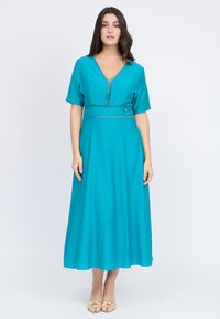 Türkises Midi-Kleid mit kurzen Ärmeln, V-Ausschnitt und dekorativen Nähten entlang der Taille. Glatter Stoff mit subtiler Textur.