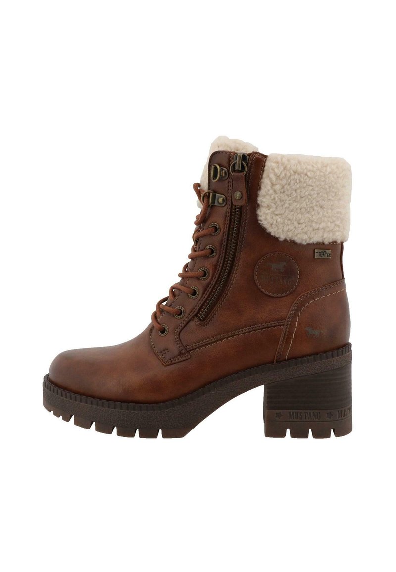 Stivale alla caviglia in pelle marrone con colletto foderato in pelliccia, allacciatura frontale, cerniera laterale e suola in gomma testurizzata. Tacco di 6,5 cm con marchiatura a caldo.