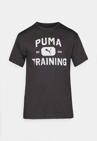 T-shirt en coton noir à manches courtes, arborant un grand graphique blanc avec l'inscription "PUMA TRAINING" et le logo Puma.