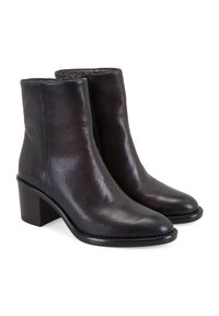 Bottines en cuir noir avec une texture lisse, un bout légèrement effilé et un modeste talon carré. Coutures visibles sur les côtés.