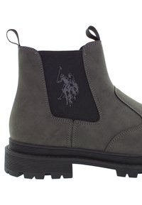 Šedé Chelsea boty s černými elastickými bočními panely, na kterých je logo polo hráče, a s poutky na patě a kotníkovém límci.