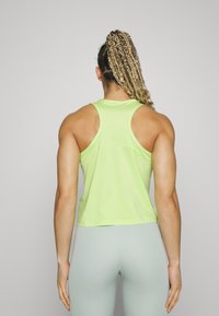 Groene tanktop met racerback-design, gemaakt van een lichtgewicht materiaal, gecombineerd met lichtgrijze leggings. Eenvoudige en aangesloten stijl.
