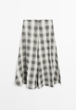Jupe en lin à carreaux gris et blanc avec un design ample, dotée d'un ourlet plissé et d'une ceinture élastique pour le confort.