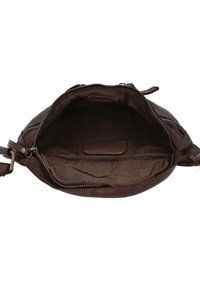 Braune Lederhandtasche, geöffnet, die einen leeren, dunkel gefütterten Innenraum mit Reißverschlussverschluss und Seitenschnalle zeigt.
