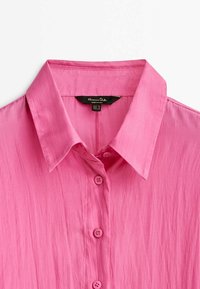 Korte mouw roze overhemd met kraag, gemaakt van lichte stof, met een licht gekreukt oppervlak en knoopsluiting aan de voorkant.