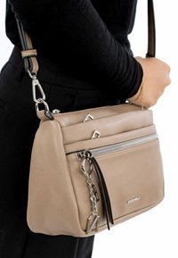 Borsa a tracolla in pelle tan con hardware silver, tasca frontale con zip e un accento decorativo a forma di portachiavi. Presenta una finitura texturizzata.