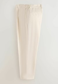 Pantalon beige texturé avec une poche arrière et une ceinture partiellement élastique, présenté plié verticalement sur un fond uni.