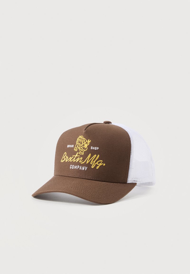 Καφέ και λευκό δίκτυ mesh trucker καπέλο με καμπύλη γείσο, κίτρινο και λευκό κεντημένο κείμενο "Brixton Mfg Company" και γραφικό στο μπροστινό πάνελ.