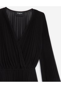 Schwarzes, plissiertes Langarm-Wickelkleid mit V-Ausschnitt und elastischem Bund, das ein transparentes, geschichtetes Stoffdesign aufweist.
