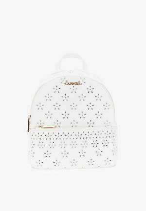 Sac à dos en cuir blanc avec motifs floraux découpés, fermeture éclair dorée et petite poignée sur le dessus.