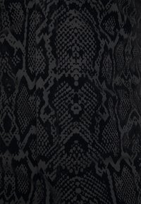 Tessuto nero con un dettagliato motivo in pelle di serpente, caratterizzato da diverse texture e tonalità, che mette in evidenza le scaglie e gli elementi di design intricati.