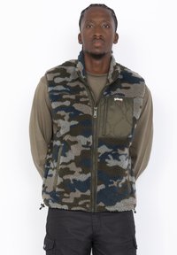 Kamizelka polarowa w wzór kamuflażu w odcieniach zieleni, niebieskiego i szarości. Posiada zamek błyskawiczny z przodu oraz kieszeń na piersi. Akcentowany design.