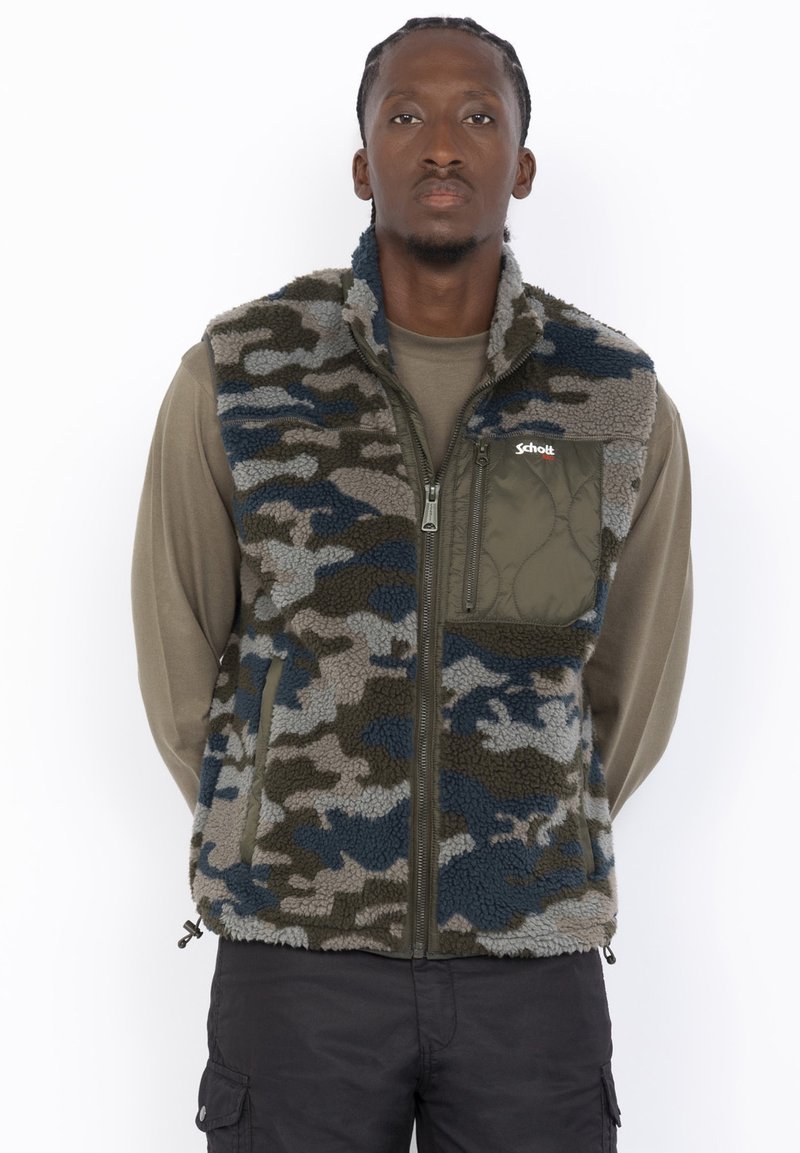 Kamizelka polarowa w wzór kamuflażu w odcieniach zieleni, niebieskiego i szarości. Posiada zamek błyskawiczny z przodu oraz kieszeń na piersi. Akcentowany design.