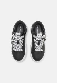 Sneaker nere con parte superiore in pelle liscia, suola in gomma bianca, lacci a fantasia neri e bianchi e dettaglio del marchio sulla linguetta.