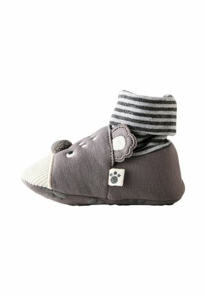 Miękka szara skarpetka-but dla niemowląt z paskowanym mankietem, detalami twarzy misia i naszywką z odciskiem łapy z boku.