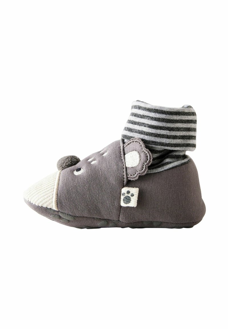 Chaussette chaussure pour bébé en gris doux avec bordure rayée, détails de visage d'ours et patch empreinte de patte sur le côté.