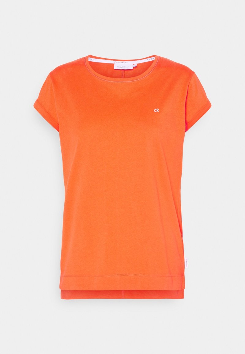 T-shirt à manches courtes de couleur orange vif avec encolure ronde, petit logo "ck" blanc sur la poitrine et détail de ourlet superposé.